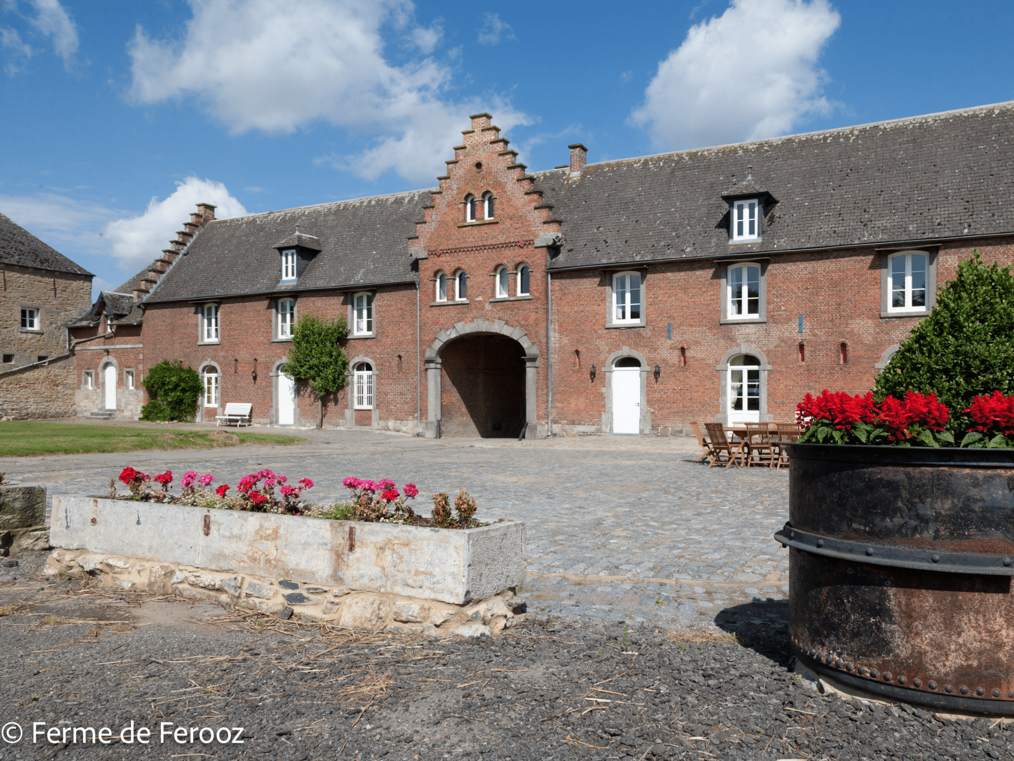 Intérieur de la Ferme de Ferooz avec des fleurs roses 